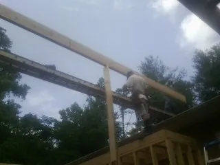 Carpenter setting a ridge beam over a new addition frame — Ice Dam Removal by Roofing Brothers in Jersey Mills