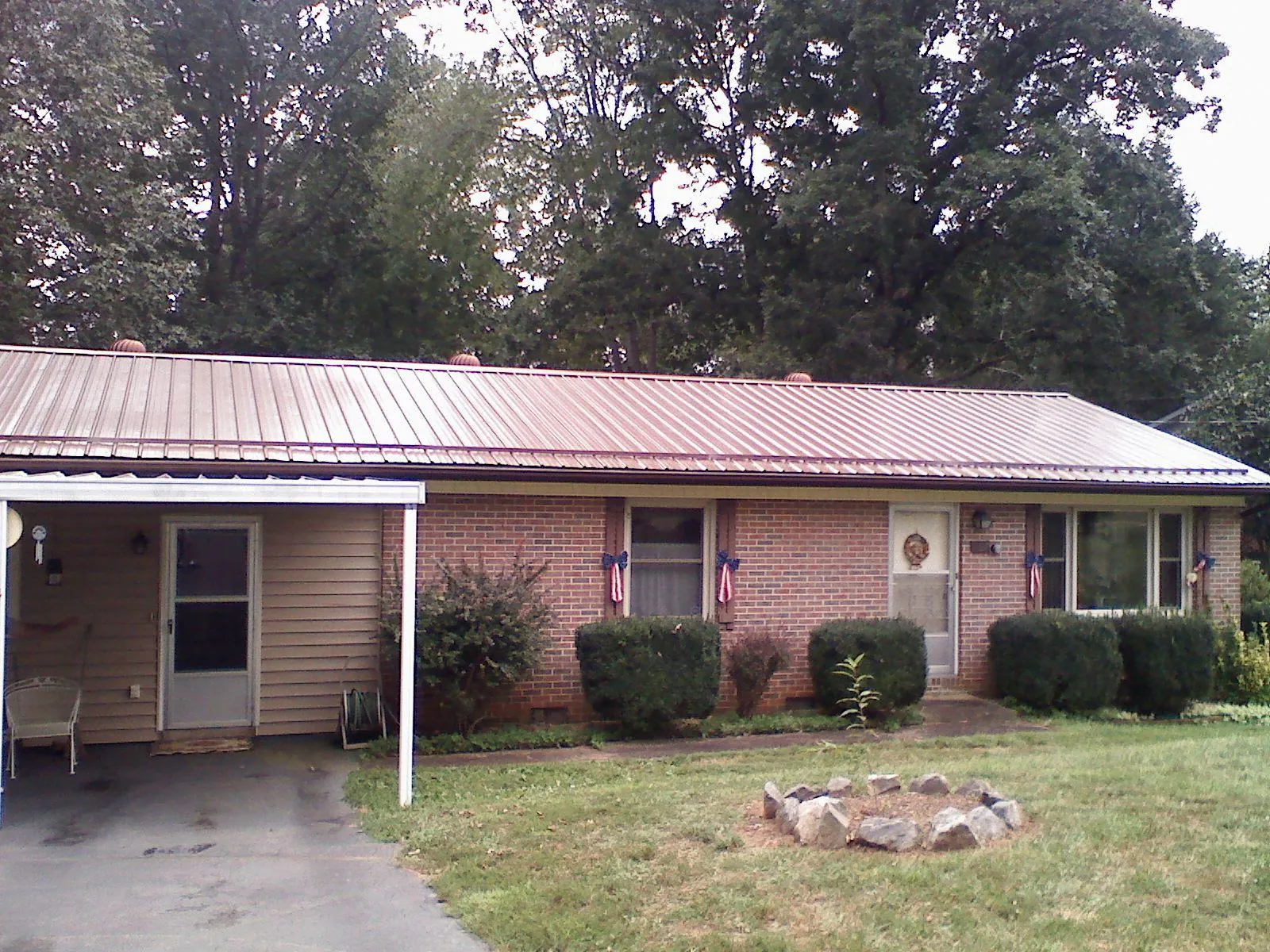 Bronze metal roof and carport on a brick ranch home — Roof Repair work by our crew in Jersey Mills